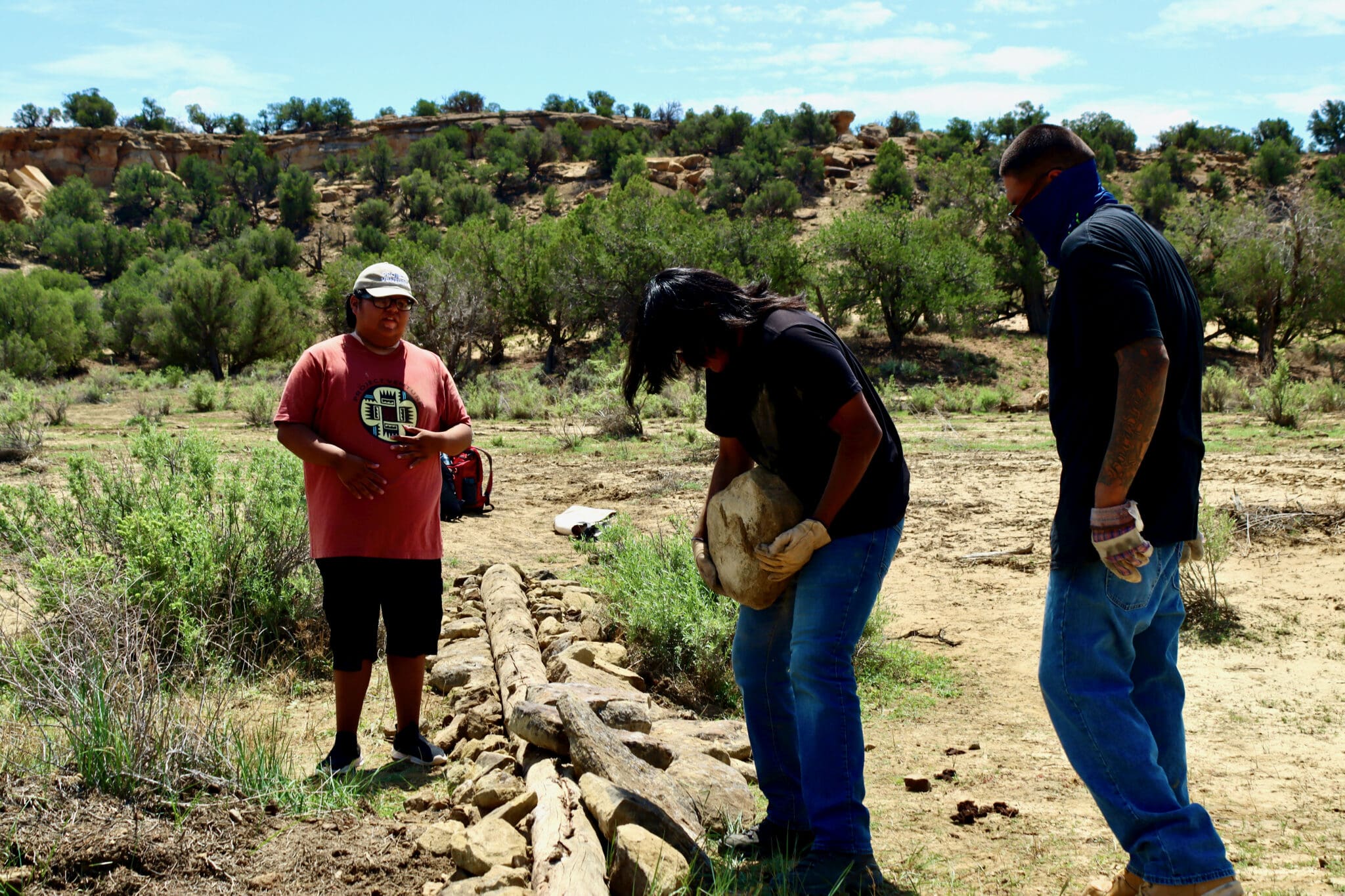 Scholars working with Watershed Crew member, Leandro Sage in maintenance of a Log Sill.