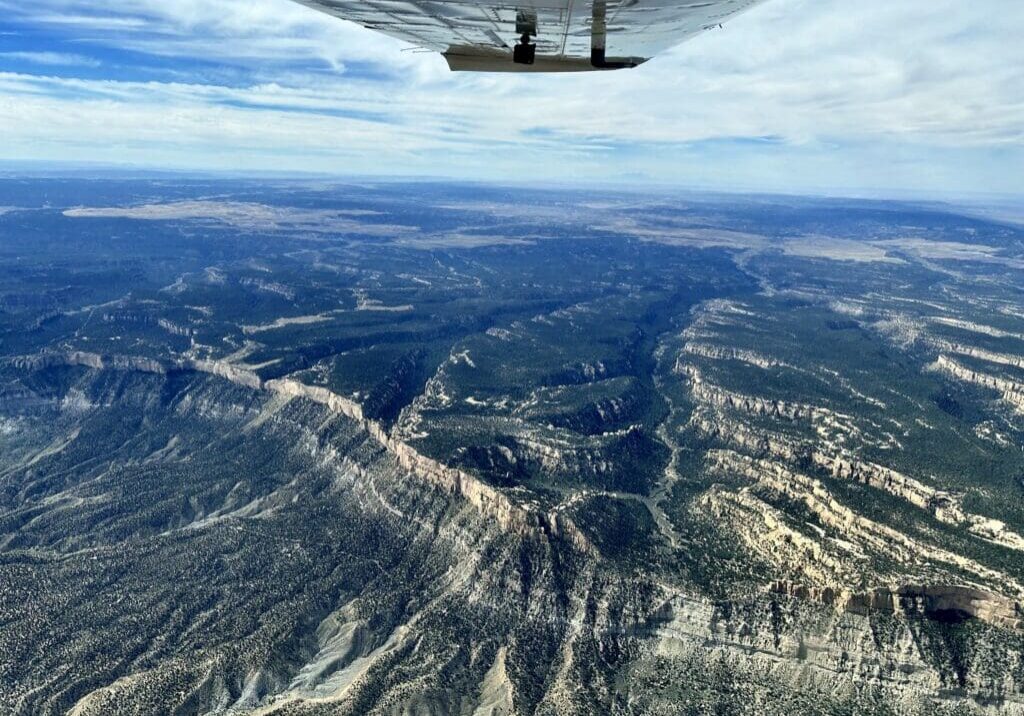 A view from the wing of a plane over a canyon.